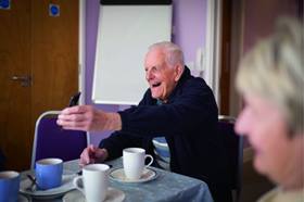 Older gentlemen laughing and showing his phone