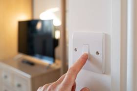 Person turning on light switch