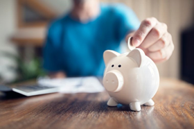 Person putting money in a piggy bank