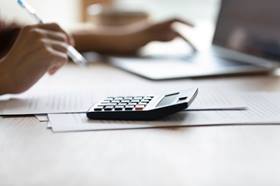 Someone sitting at a desk with a calculator