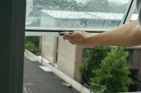 An arm opening a window with condensation on 