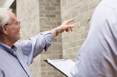 Man pointing at brickwork